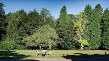 Un parc amb zona de pícnic i un estany.