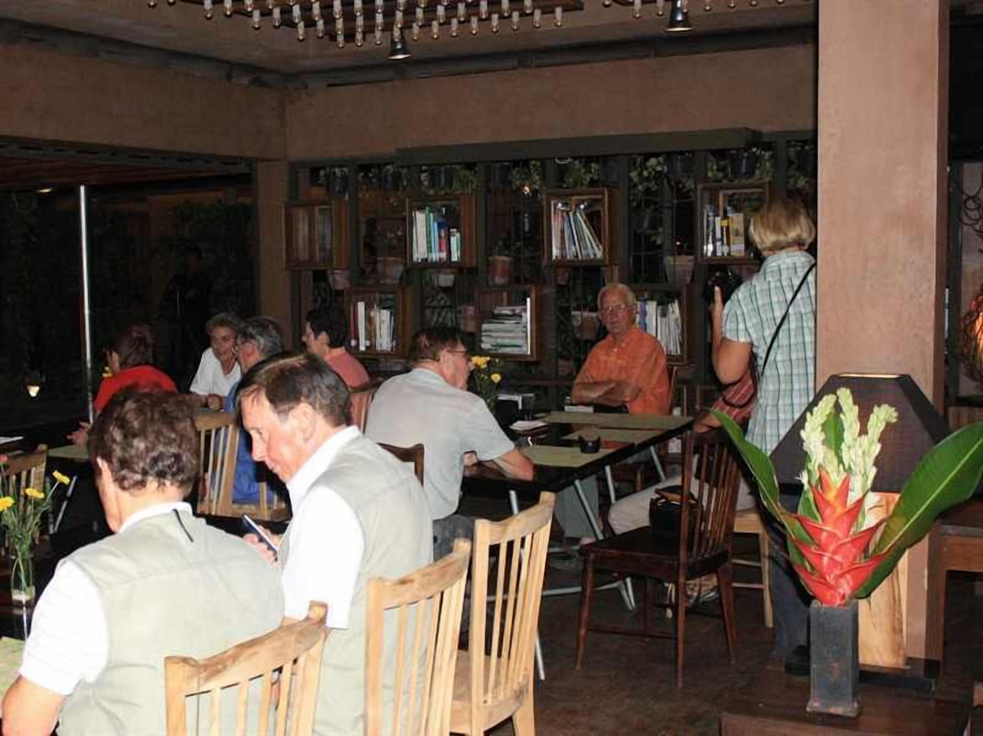 En restaurant med træmøbler og en reol fyldt med bøger.