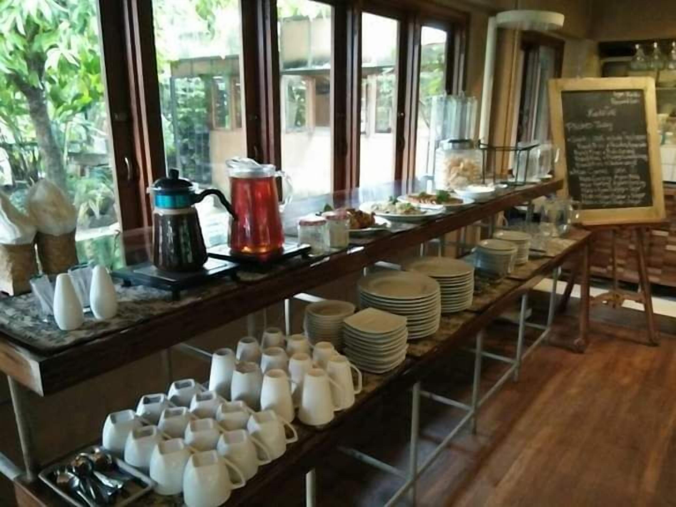 Un buffet proposant divers plats, un coin café et un menu écrit à la craie.