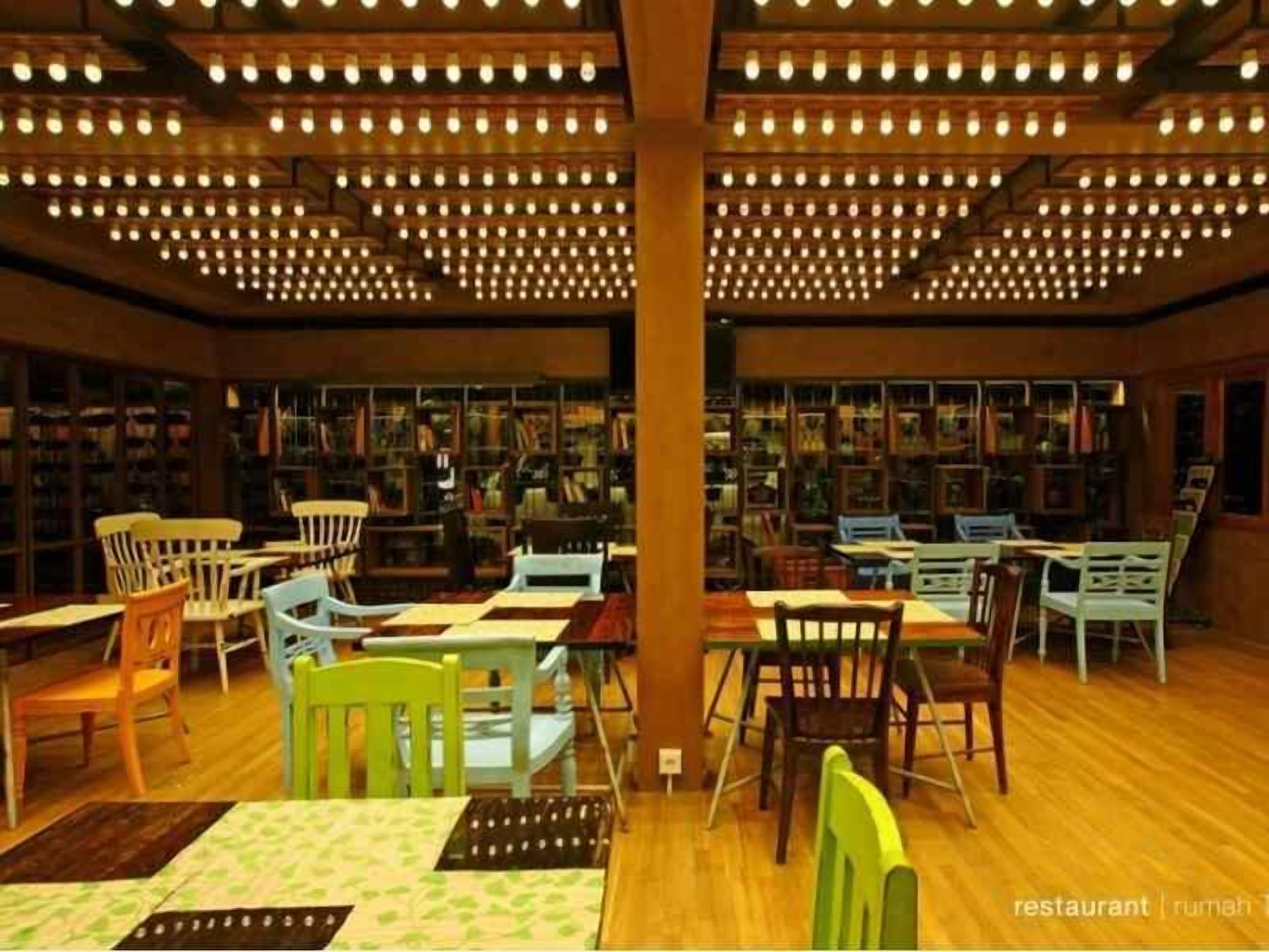 A library with rows of bookshelves and tables with chairs.