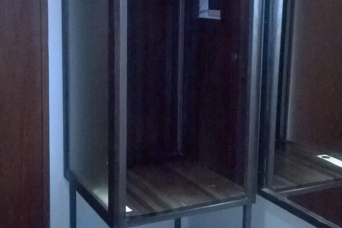 A room with a wardrobe, a mirror, and a small table.