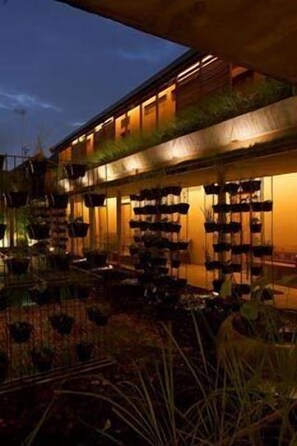A modern building with multiple balconies, each with hanging planters. - Rumah Turi Eco Hotel (Surakarta)