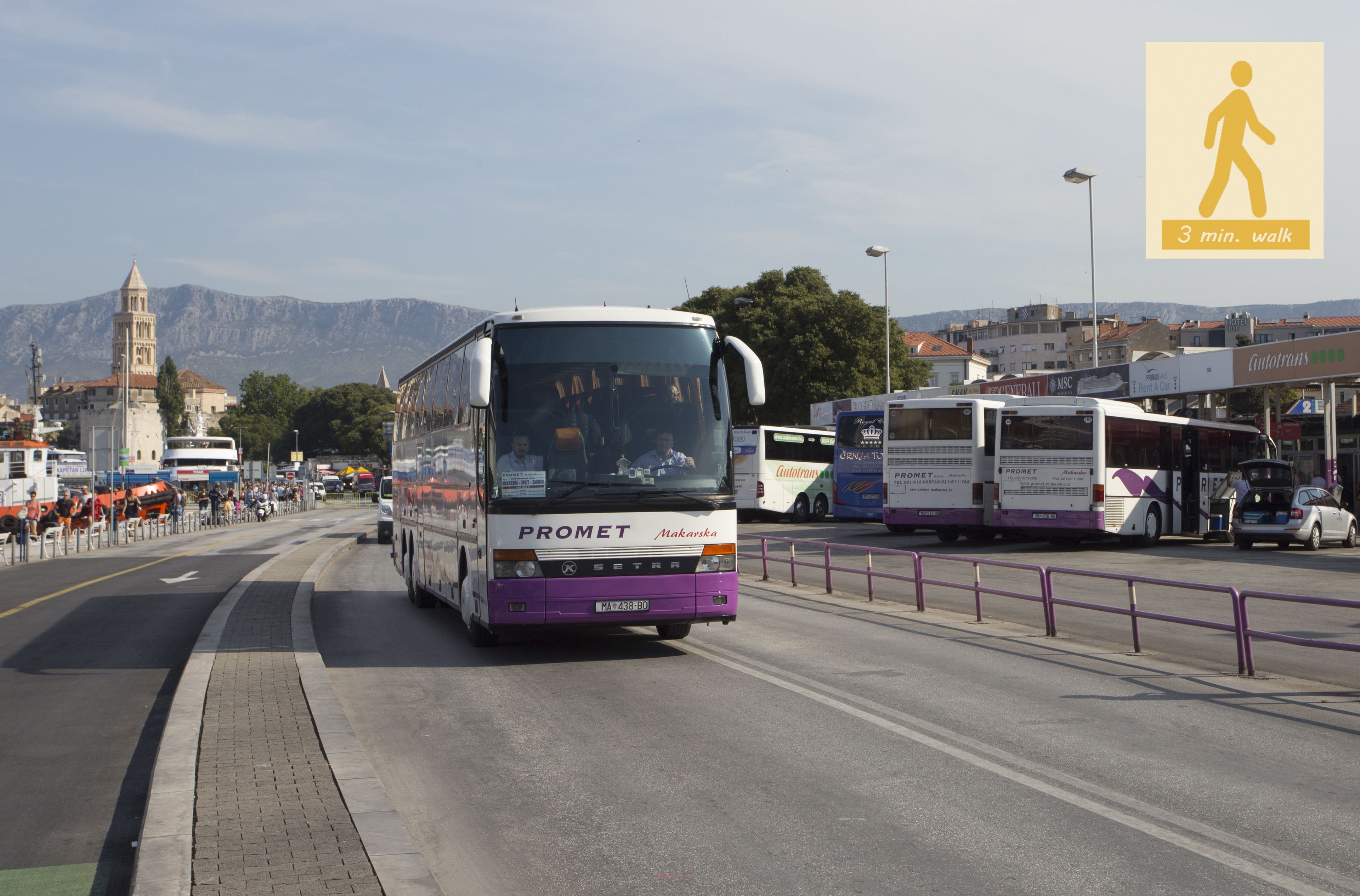 Ein Bus mit den Aufschriften "PROMET" und "Makarska" auf der Front fährt auf einer Straße, im Hintergrund ist ein Fußgängerüberwegschild zu sehen.