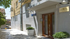 Un edificio con un letrero que dice "Royal Suites", una planta en maceta, una puerta y una ventana.