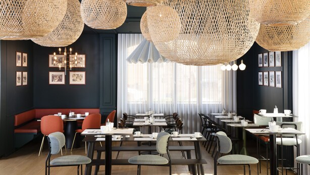 A restaurant with round tables, red cushioned seating, and large woven light fixtures.