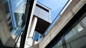 A modern building with reflective glass windows and a concrete structure.