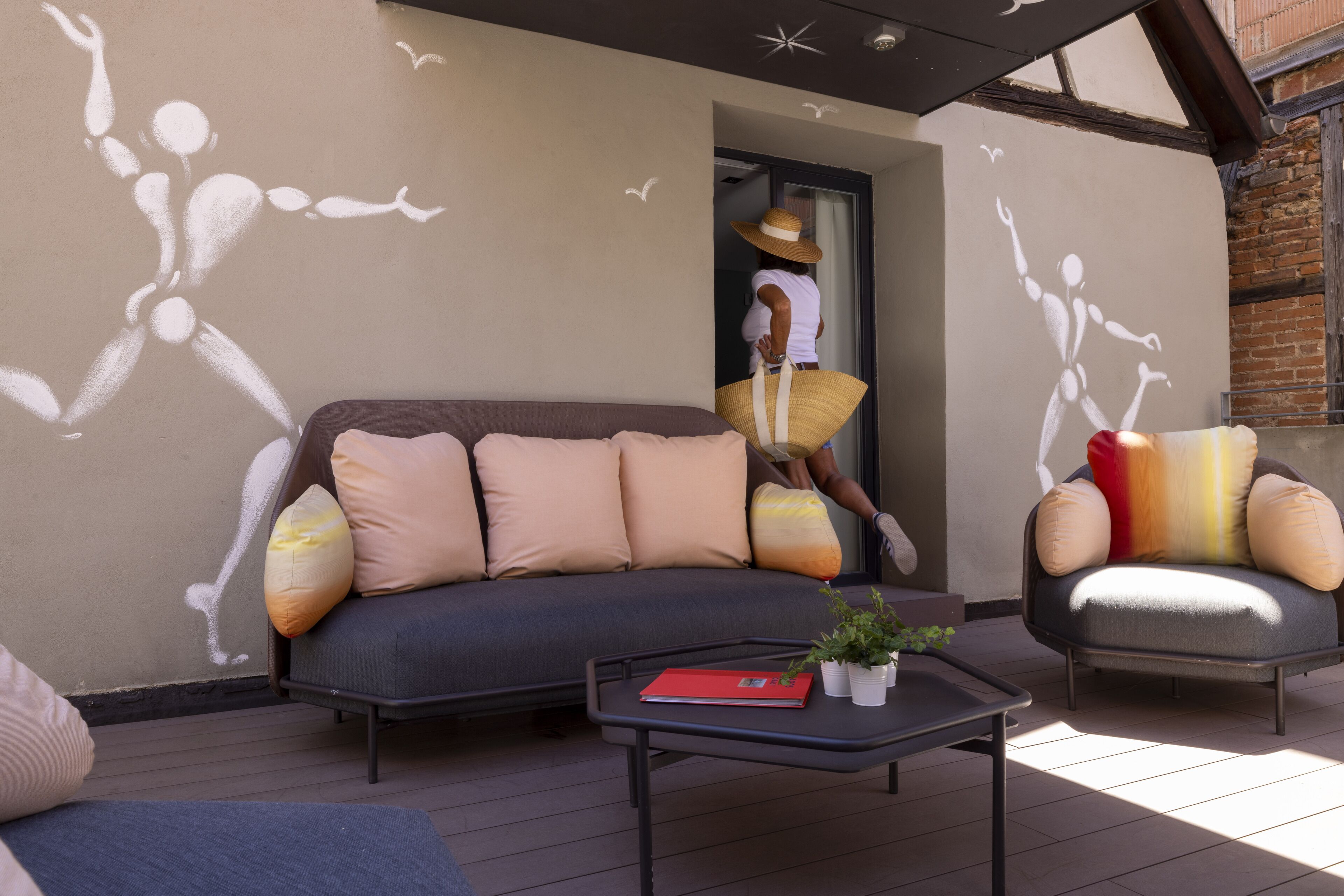 Un espace extérieur aménagé avec un canapé, un fauteuil et une table basse.