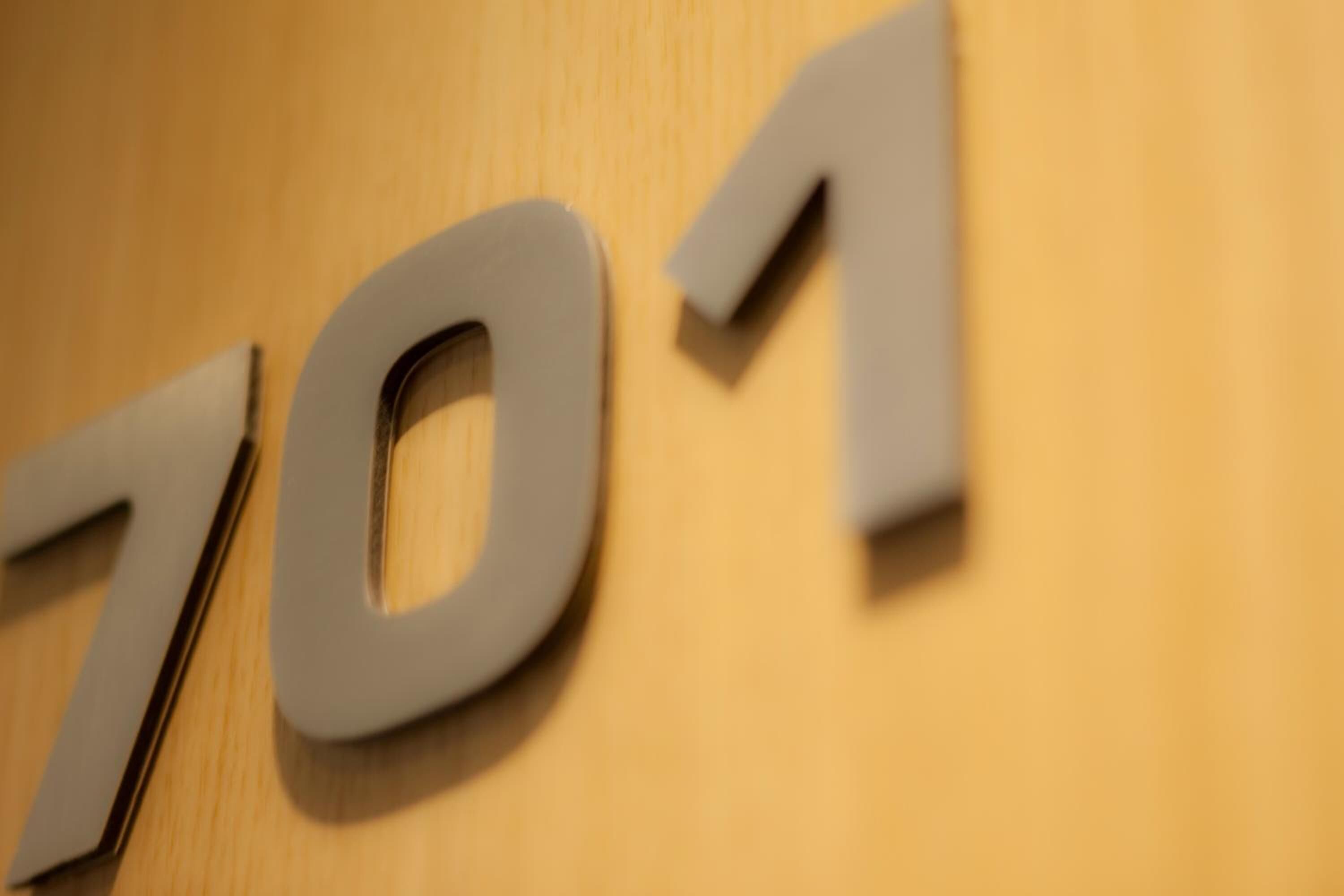 A close-up of the numbers "701" on a wooden surface.