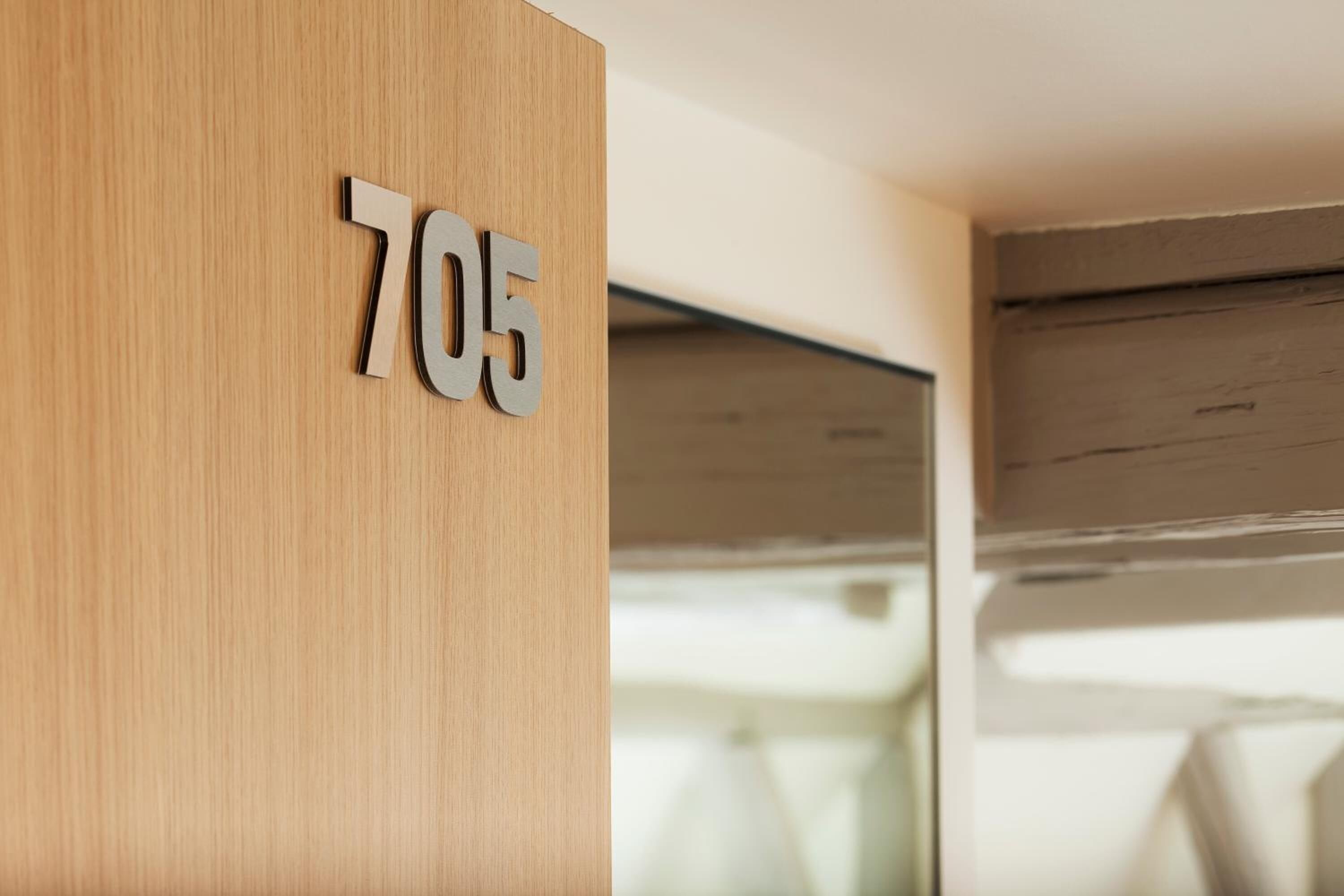 A wooden wall with the number 705.