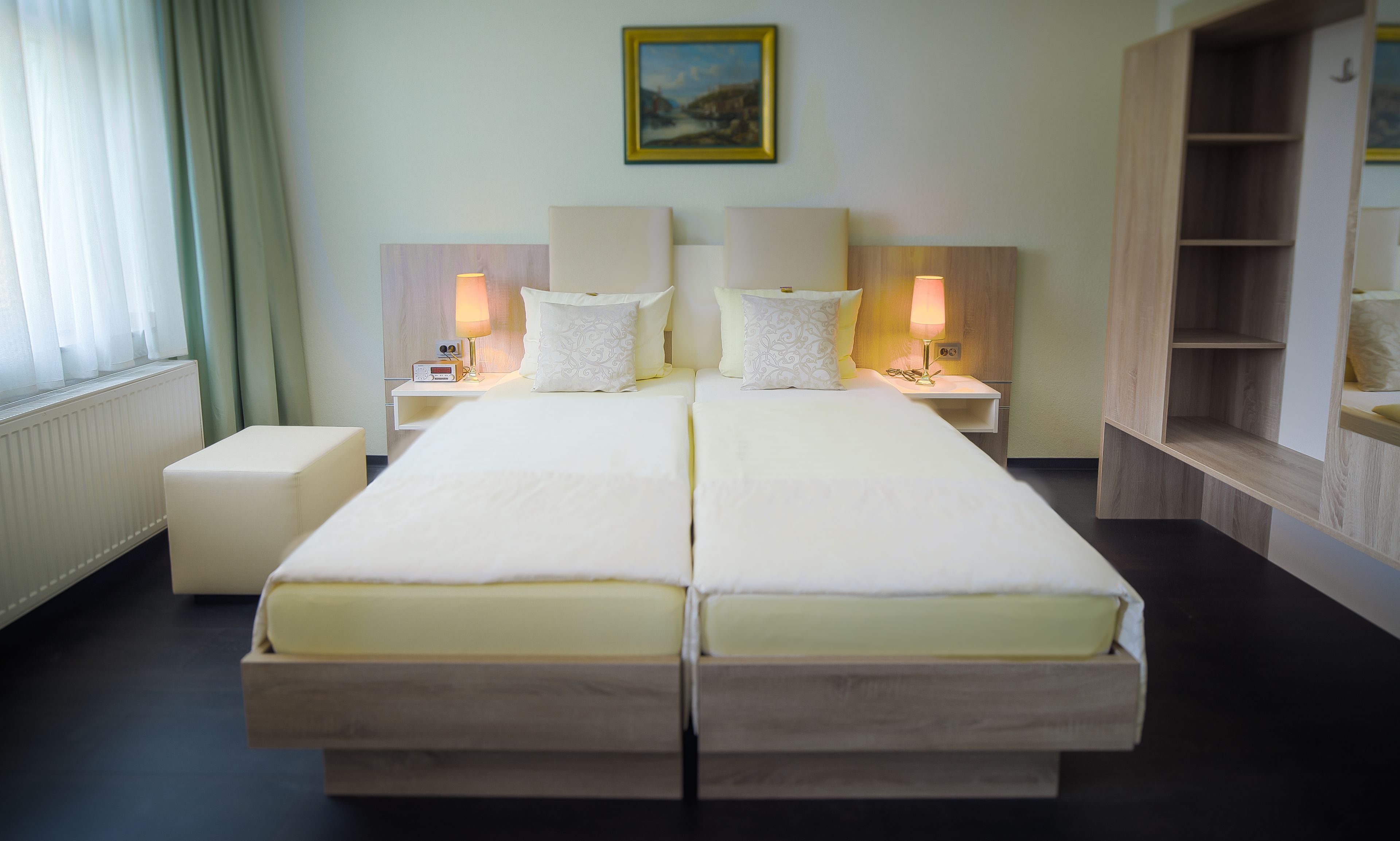 Uma cama de casal com duas mesas de cabeceira, cada uma com uma luminária, em um quarto de hotel.