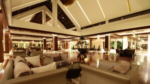 A spacious lobby with high ceilings, a central coffee table, and multiple seating areas. - Jaypee Greens Golf & Spa Resort (Greater Noida)