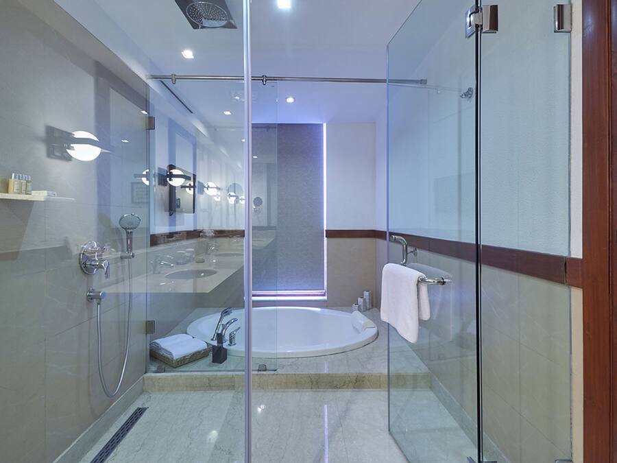 A modern bathroom with a glass-enclosed shower, a standalone bathtub, and a large mirror.