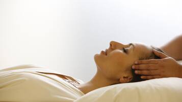 A person lying in bed with a hand on their head, suggesting a relaxed or contemplative state.