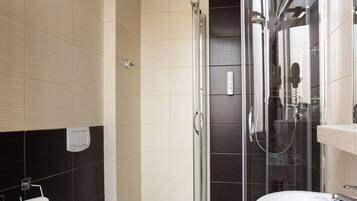 Une salle de bain moderne équipée de toilettes, d’une douche et d’un lavabo.