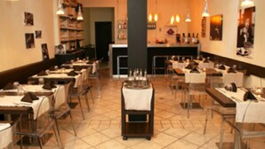 A restaurant with multiple tables and chairs, a central bar area, and various wall decorations. - Cruz Bay Boutique Hotel (St. John)