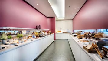 Una cocina moderna con una isla central, equipada con diversos electrodomésticos y una variedad de alimentos exhibidos sobre la encimera.