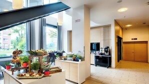 Un moderno vestíbulo de hotel con una recepción, una estación de café y vistas al exterior.