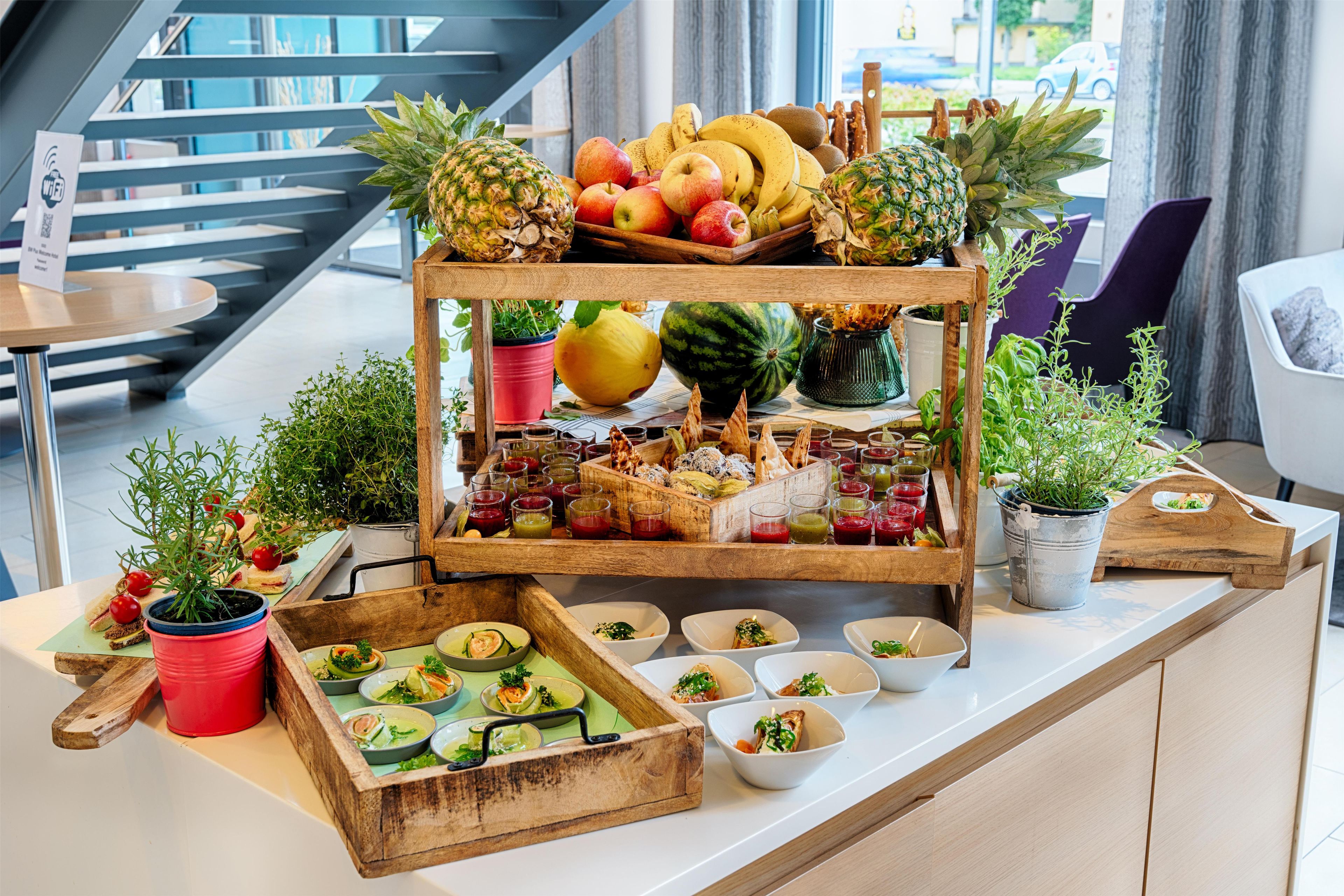 A buffet table with various fruits, vegetables, and dishes.