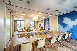 Una sala de conferències amb una taula llarga, cadires i un gran finestral.