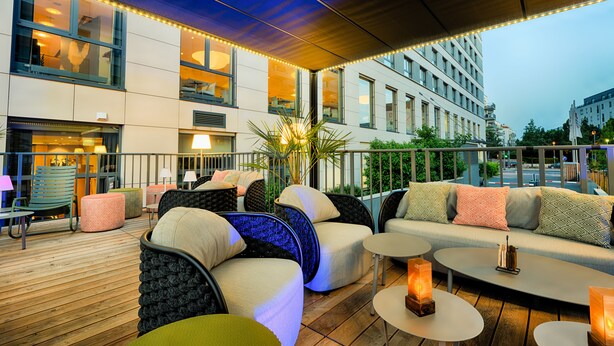 An outdoor seating area with sofas, chairs, and tables, featuring a modern design and ambient lighting. - Best Western Plus Welcome Hotel Frankfurt (Frankfurt)