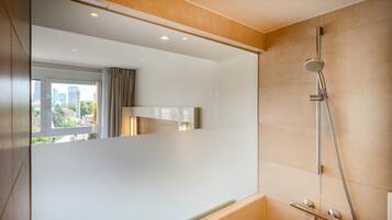 Ein modernes Badezimmer mit Dusche, einem Fenster mit Vorhängen und Blick auf die Stadt.