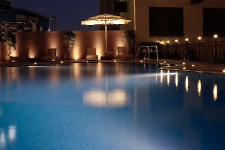 Alberca al aire libre, sombrillas en la alberca y camastros