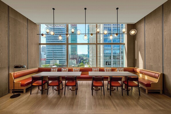 A modern dining area with a long table, multiple chairs, and a large window offering a city view. - W Taipei (Taipei)