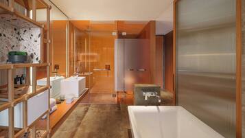 A modern bathroom with a large bathtub, wooden shelving with toiletries, and a glass shower enclosure.
