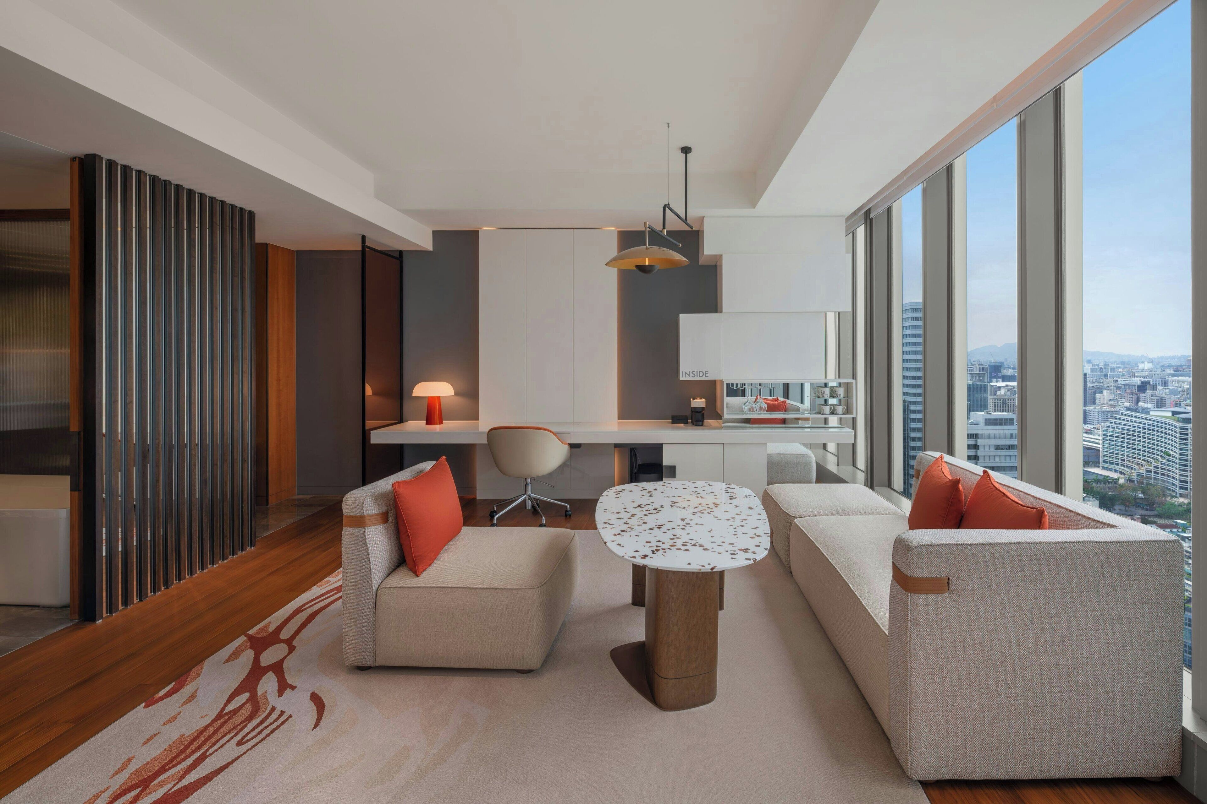 A modern living room with a sofa, armchair, and a small round table.