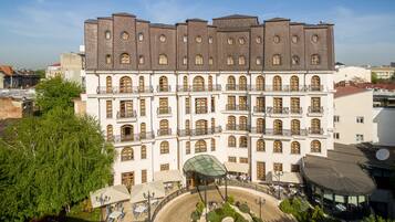 Experience the charm of this historic building with its classical design, arched windows, and outdoor seating areas.