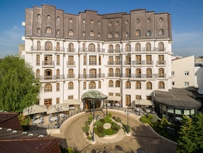 A large, multi-story hotel with a symmetrical facade, numerous balconies, and a central courtyard with outdoor seating.