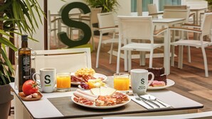 A breakfast setting with a table, chairs, and a large 'S' decoration. - Hotel Sercotel Coliseo (Bilbao)