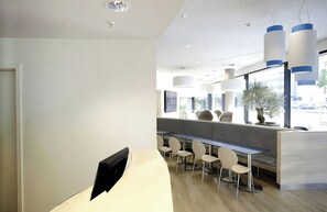 Un interior moderno con una larga encimera, zona de estar y amplias ventanas.