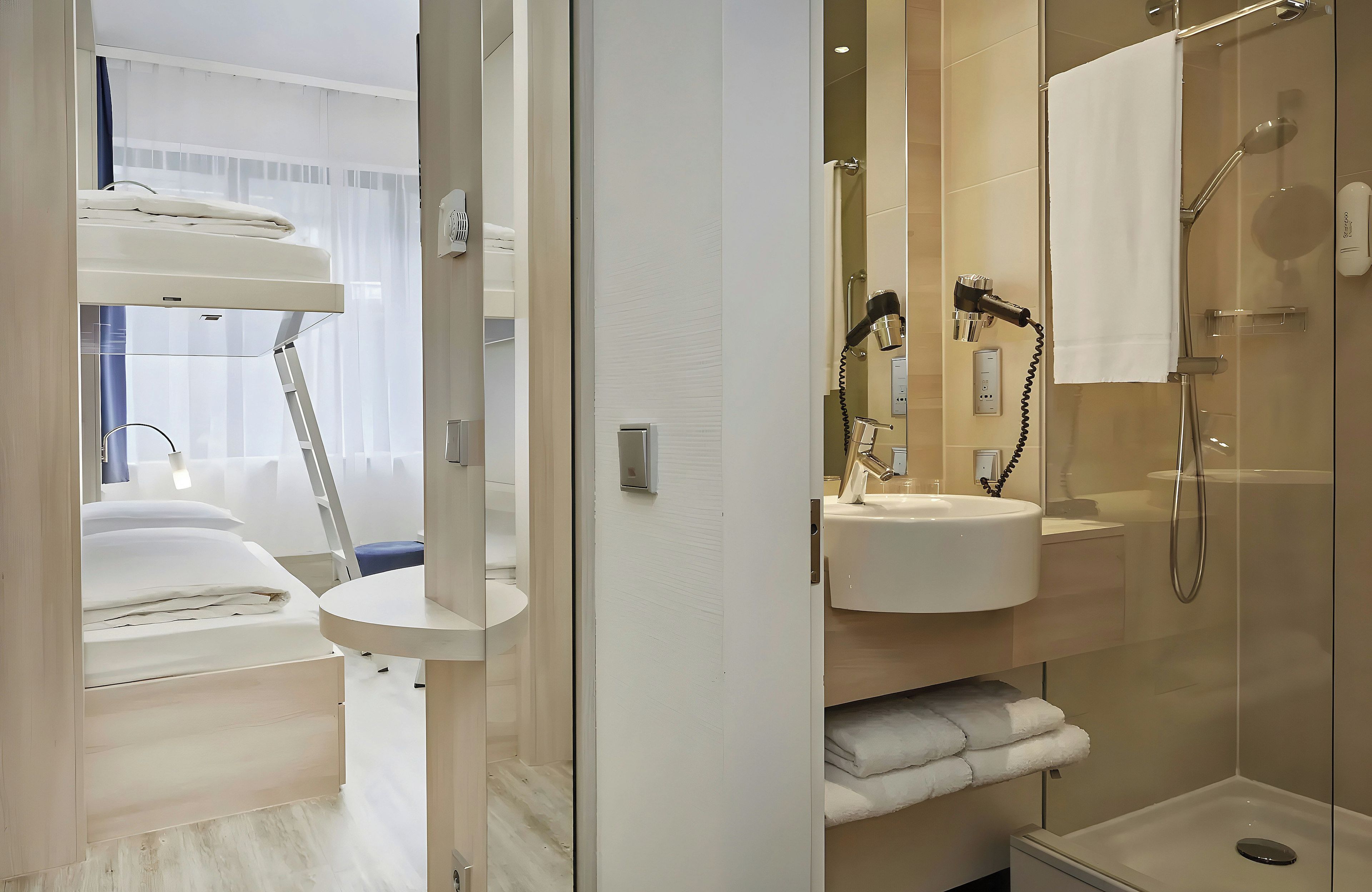 A modern bathroom with a shower, a sink, and a hairdryer mounted on the wall.