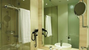 A modern bathroom with a glass-enclosed shower, a sink with a mirror above it, and a towel rack. - Leonardo Smart Hotel Berlin Alexanderplatz (Berlin)