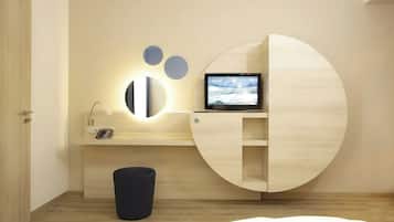 A modern room with a built-in desk, a television, and a trash bin.