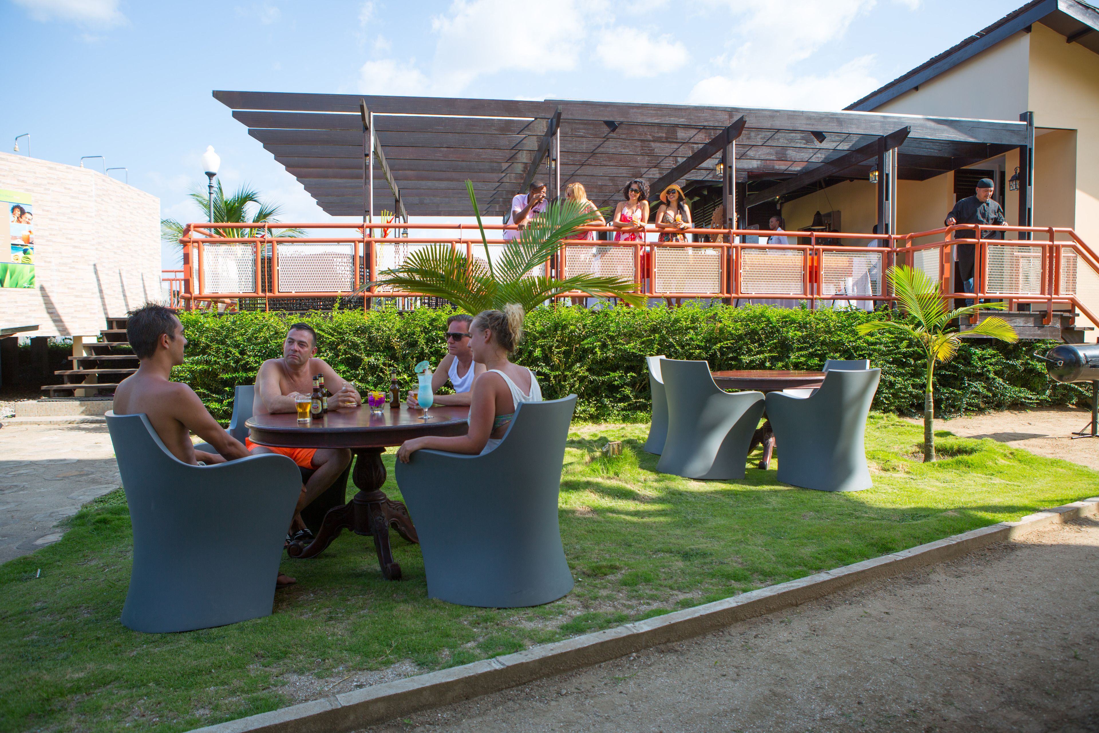 Een terras met buitenmeubels en een overdekt gedeelte.