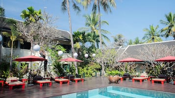 Relax by the serene pool surrounded by lush tropical vegetation and modern architecture.
