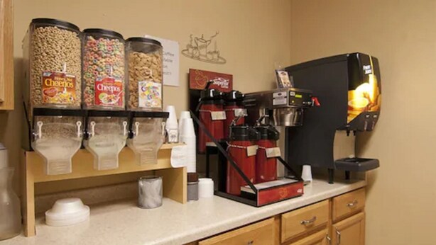 Un espace dédié au café, équipé d’une machine à café et de distributeurs de crème et de sucre.