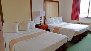 Une chambre d’hôtel avec deux lits, une table de chevet avec une lampe, un miroir et une fenêtre avec des rideaux.