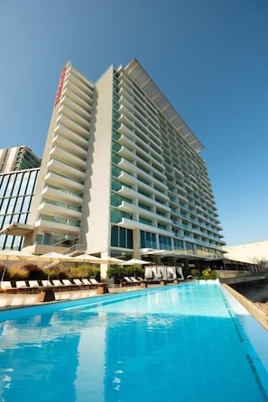 A high-rise hotel with a pool in front. - Terrado Suites Antofagasta (Antofagasta)