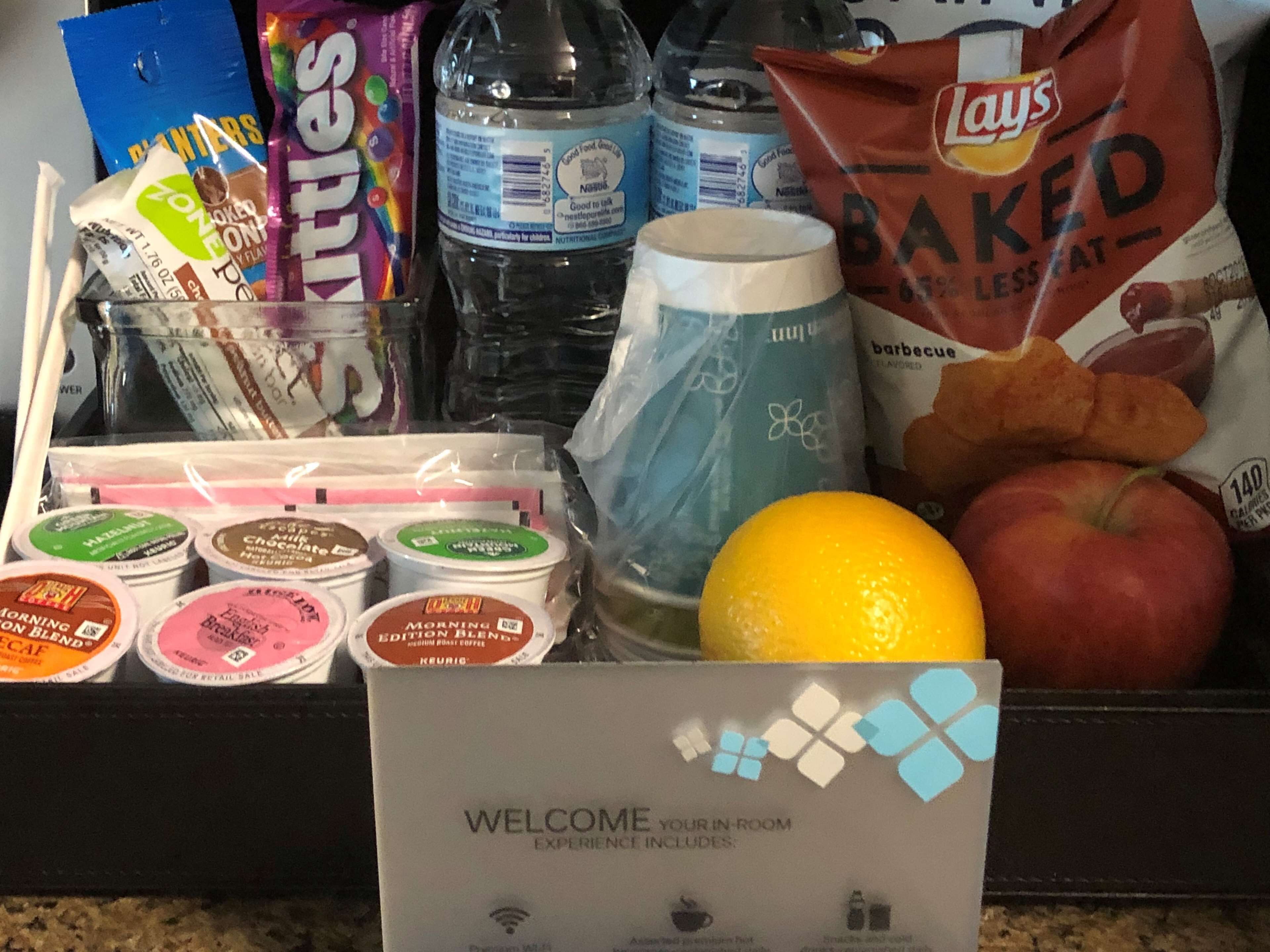 A variety of food items including snacks, drinks, and breakfast items in a tray.