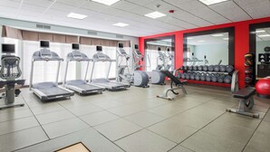 Gimnàs amb cintes de córrer, màquines el·líptiques i equip per a musculació.