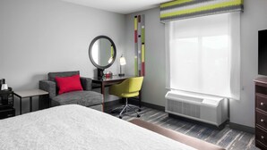 A hotel room with a bed, a desk with a chair, a mirror, a lamp, and a window with a view. - Hampton Inn & Suites Birmingham/280 East-Eagle Point (Birmingham)