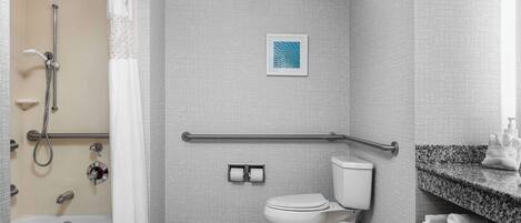 A bathroom with a shower, toilet, and a towel rack.