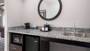 A compact kitchen with a built-in microwave, dishwasher, and sink. A coffee maker and a tea kettle are on the counter. - Hampton Inn & Suites Birmingham/280 East-Eagle Point (Birmingham)
