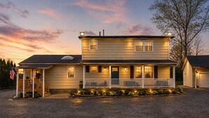 A two-story house with a porch, a garage, and a driveway. - OYO Hotel Starlite Seneca Falls (Seneca Falls)