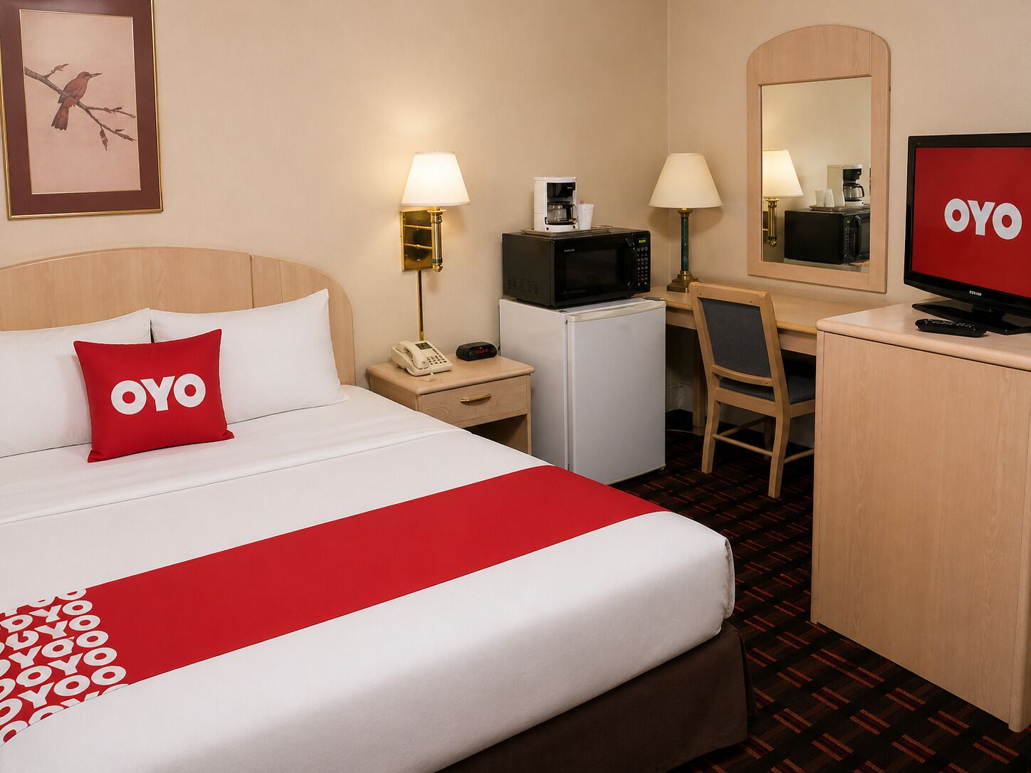 A hotel room with a bed, a desk, a TV, a microwave, a refrigerator, and a telephone.
