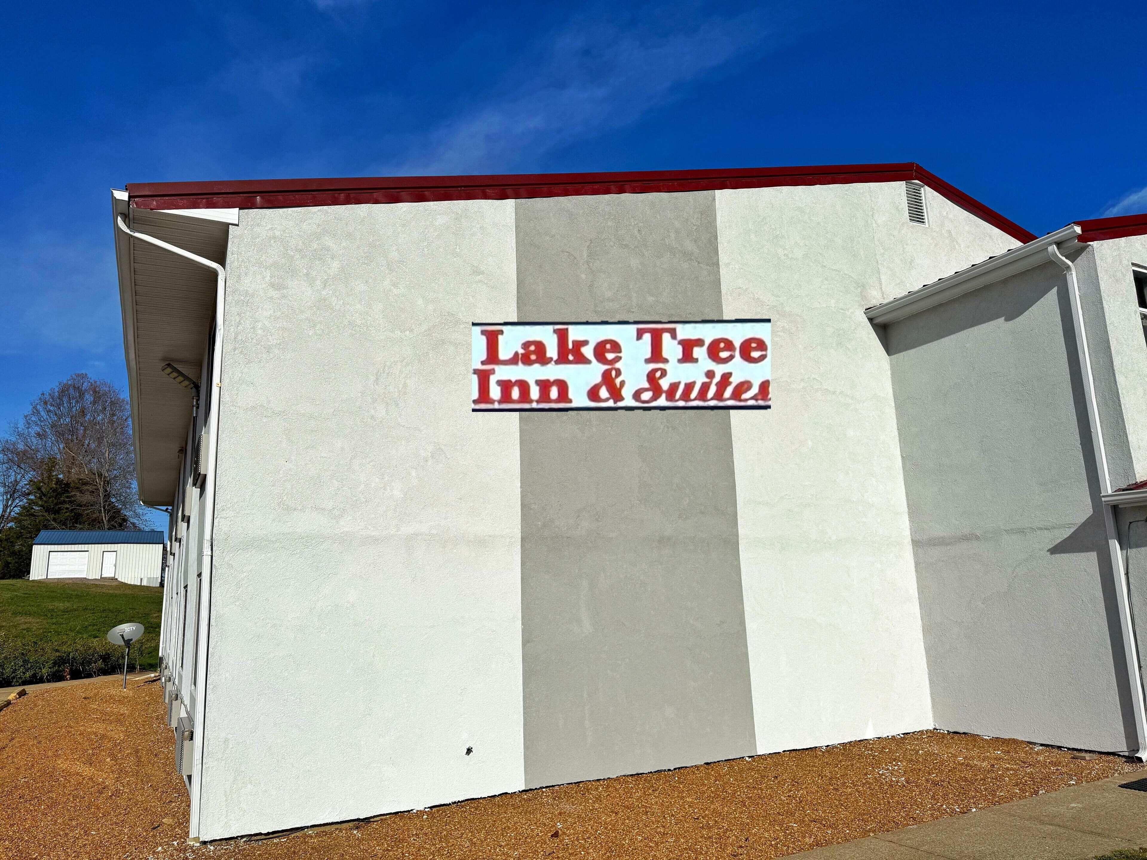 A building with a sign reading "Lake Tree Inn & Suites".