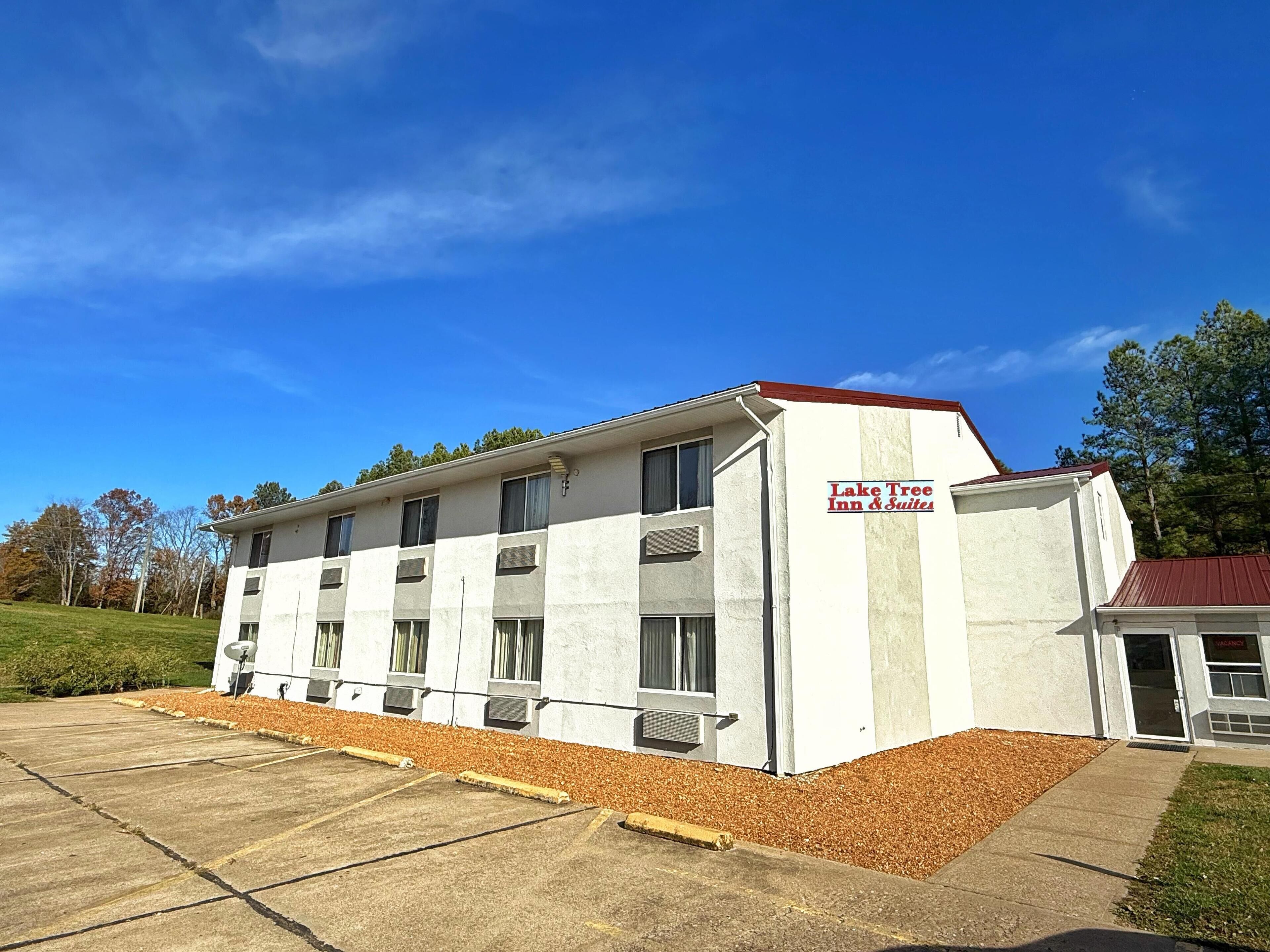 Un immeuble à plusieurs étages sur lequel on peut lire l’inscription : « Lake Tree Inn & Suites ».